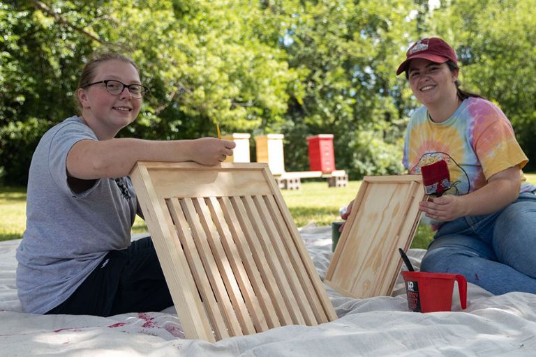 Students paint a beehive in Indiana University colors