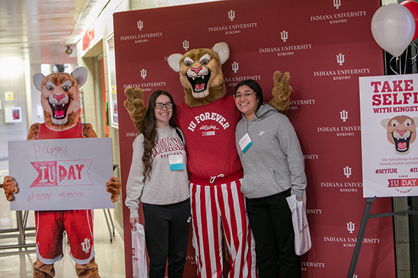 Two students standing with Kingston.