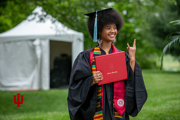 An IU Kokomo graduate holding a diploma.