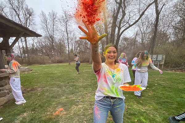 a woman throws powdered paint at the camera.
