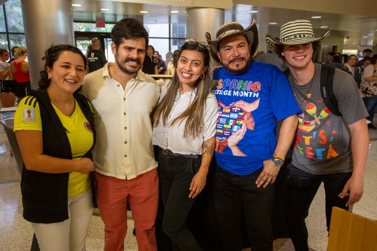 Five students and faculties posing for a group photo.