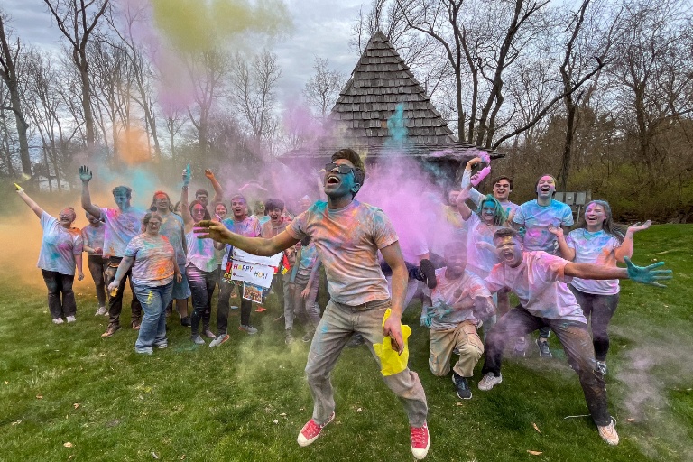 A man jumped in front of a group of men and women posing for the camera.