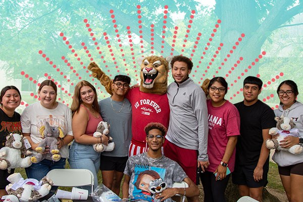a group of students posing with the Kingston Cougar mascot