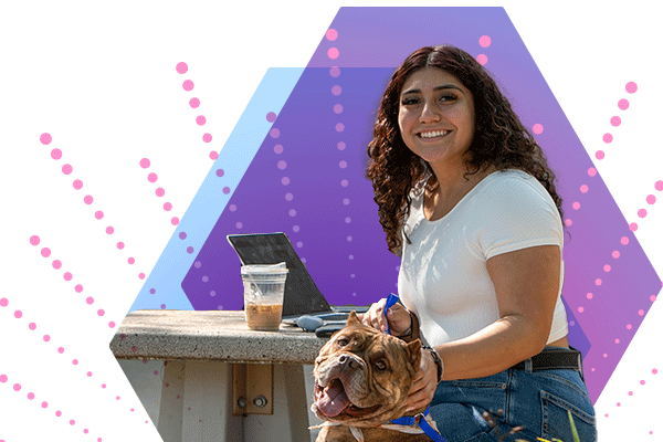 IUK student sitting at an outdoor table with her laptop and iced coffee