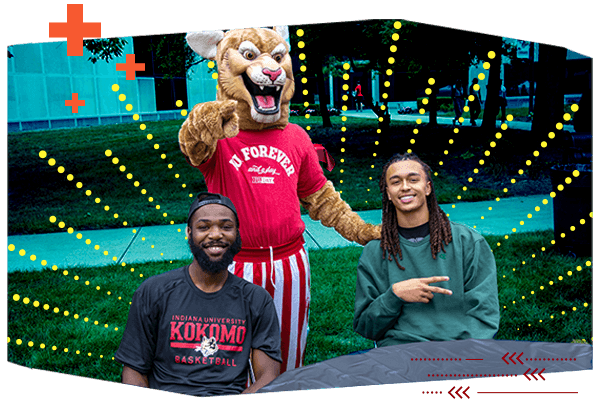 2 male students pose with the school mascot Kingston Cougar