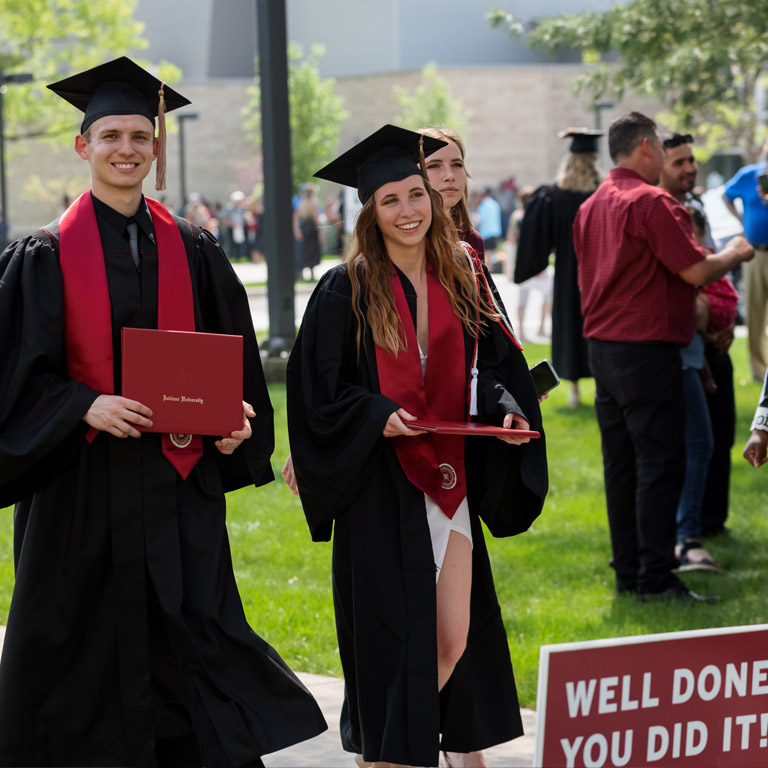 A pair of IUK grads walk campus after the ceremony