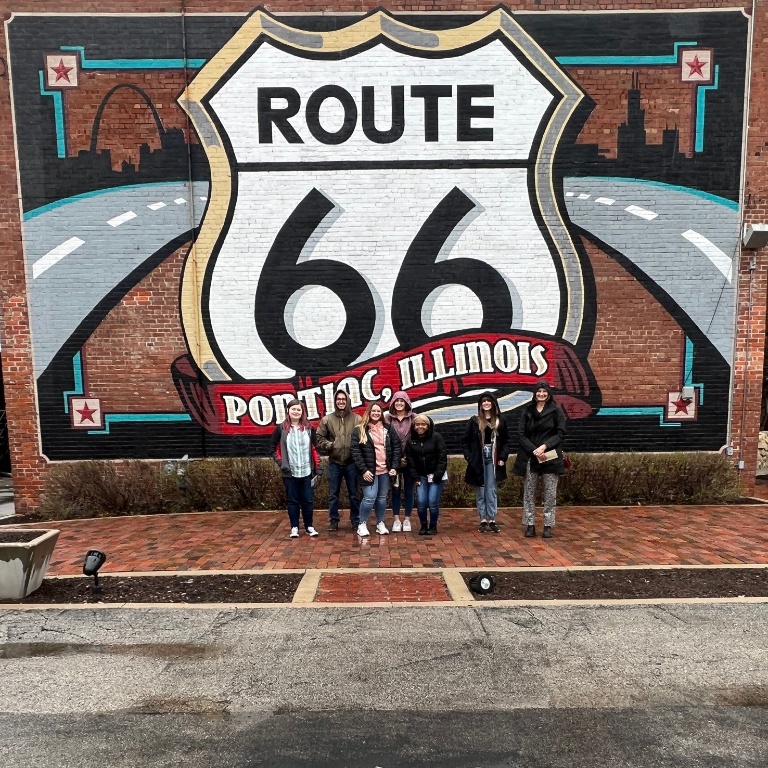 Students standing in front of Route 66 sign.