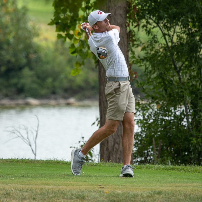 student athlete swinging a golf club