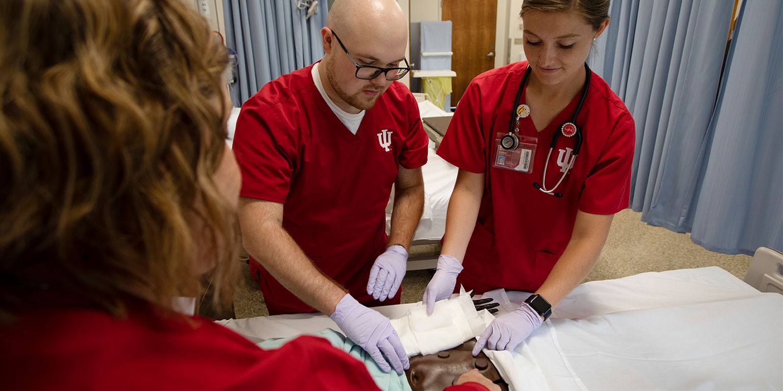 Two nursing students prepping a patient.